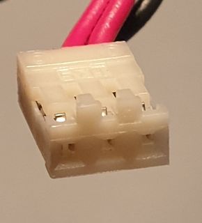 Weißer Kunststoffstecker mit roten und schwarzen Kabeln