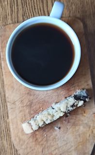 Kaffee und Keks auf Holzbrett