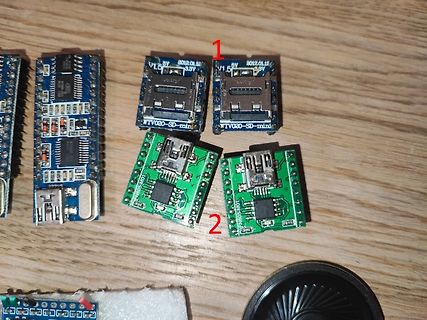 Verschiedene Mikrocontroller-Module und SD-Karten-Adapter auf Holzuntergrund