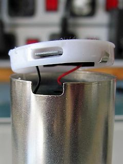 Elektronikbauteil mit weißem Gehäusedeckel und Metallzylinder