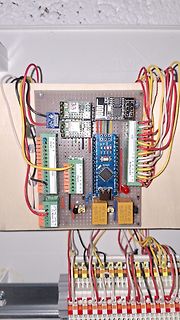 Elektronik-Aufbau auf Holzbrett mit Mikrocontroller und Relais