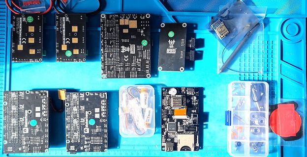 Verschiedene Mikrocontroller-Platinen und Elektronikbauteile auf Werkstattunterlage