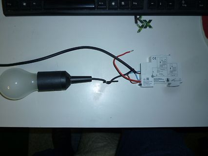 Glühbirne mit angeschlossener Elektronik auf Tisch