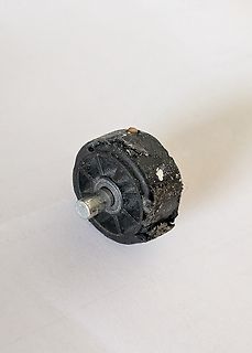 Beschädigtes schwarzes Bauteil mit Metallstift