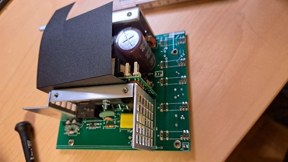 Geöffnetes Netzteil mit Leiterplatte und Bauteilen