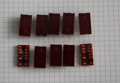 Zehn kleine rote Leiterplatten auf Millimeterpapier