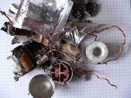 Zerstörte elektronische Bauteile und Metallreste