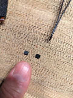 Zwei kleine SMD-Bauteile auf Holzuntergrund