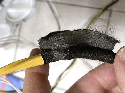 Beschädigte Isolierung eines gelben Kabels