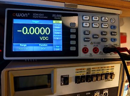 Digitalmultimeter und Netzteil auf einem Arbeitstisch