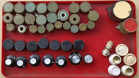Verschiedene Drehregler und Potentiometer in einer roten Schale