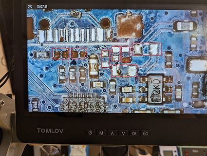 Mikroskopaufnahme einer beschädigten Leiterplatte auf Display