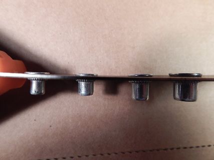 Nahaufnahme von vier Metallstiften an einer Kante