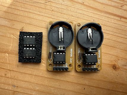 Zwei RTC Module und ein Bauteil auf Holz