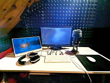 Arbeitsplatz mit Monitoren, Mikrofon und Kopfhörern