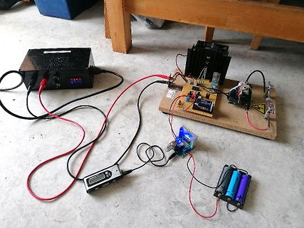 Elektronik-Versuchsaufbau mit Netzteil, Batterien und Platinen