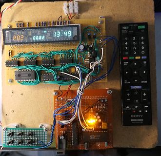 Elektronik-Prototyp auf Holzbrett mit Display und Fernbedienung
