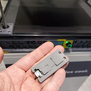 Graues Kunststoffgehäuse mit elektrischem Anschluss in Hand