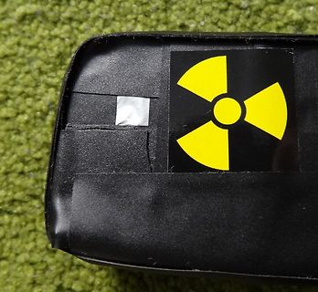 Schwarzer Gegenstand mit Radioaktivitäts-Warnsymbol