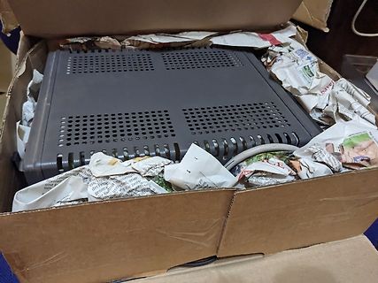 Elektronikgerät in einem Karton mit Zeitungspapier