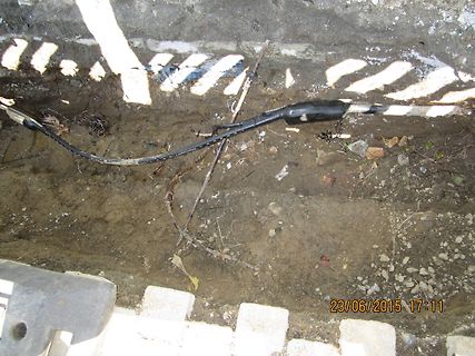 Schwarzes Kabel in einer Erdgrube