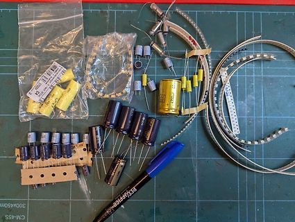 Elektronikbauteile wie Kondensatoren und LED-Streifen auf Schneidematte