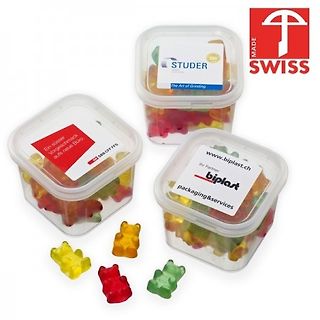 Drei Behälter mit Gummibärchen und lose Gummibärchen
