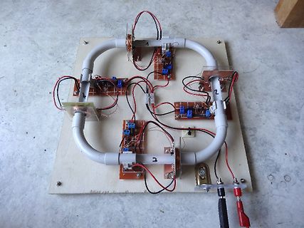 Elektronischer Aufbau mit Spulen und PVC-Rohren auf Holzplatte