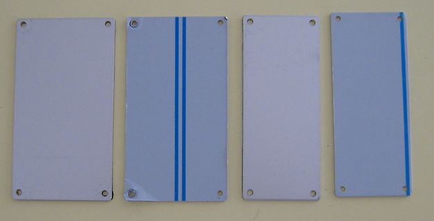 Vier rechteckige Metallplatten mit Löchern