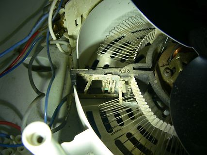 Innenansicht eines elektrischen Geräts mit Kabeln und Metallfedern