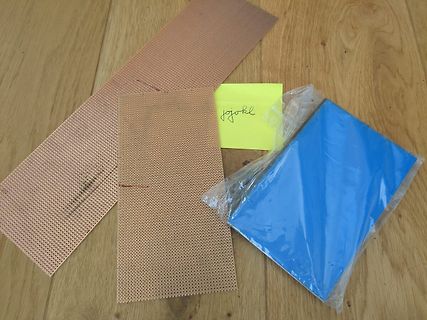 Lochrasterplatinen, gelber Zettel und blaues Material auf Holz