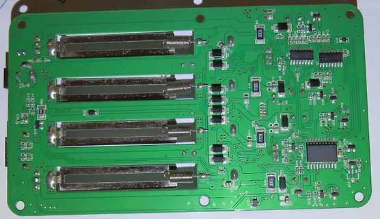 Grüne Leiterplatte mit vier Schienen und elektronischen Bauteilen