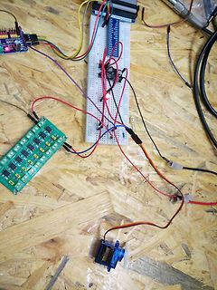 Elektronik-Versuchsaufbau mit Breadboard, Mikrocontroller und Servomotor