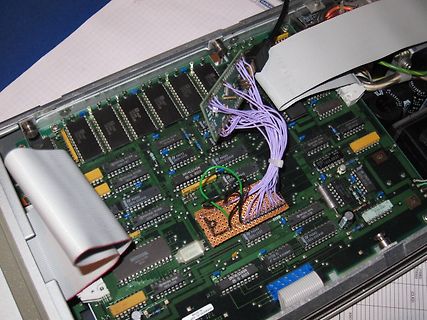 Geöffnete Elektronik mit Leiterplatte und Flachbandkabel