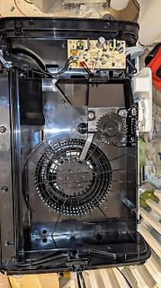 Innenansicht eines geöffneten Elektrogeräts mit Platine und Lüfter
