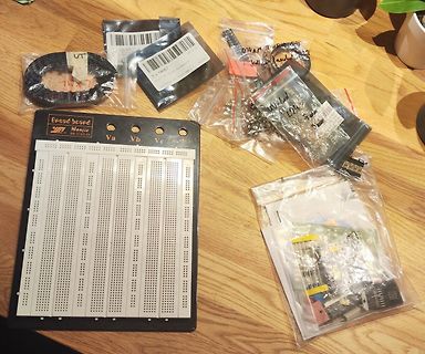 Breadboard, Bauteile und Kabel auf Holztisch