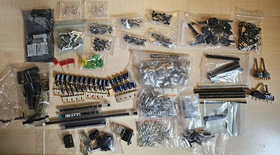 Verschiedene elektronische Bauteile in Plastikbeuteln auf Holztisch