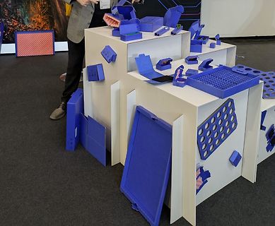 Blaue Kunststoffboxen auf weißen Podesten