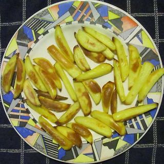 Gebratene Kartoffelspalten auf einem gemusterten Teller