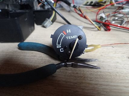 Temperaturregler auf Werkstattuntergrund mit Zange