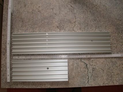Aluminiumprofile und Maßband auf Tischplatte