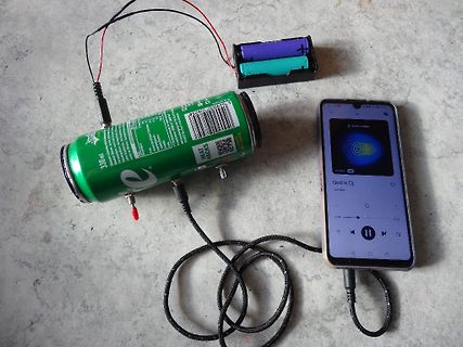Getränkedose, Batterien und Smartphone mit Kabelverbindung