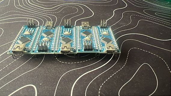 Vier Mikrocontroller-Entwicklungsboards auf gemustertem Untergrund