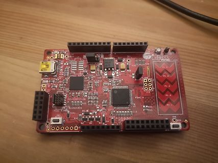 Rote Mikrocontroller-Leiterplatte auf Holztisch
