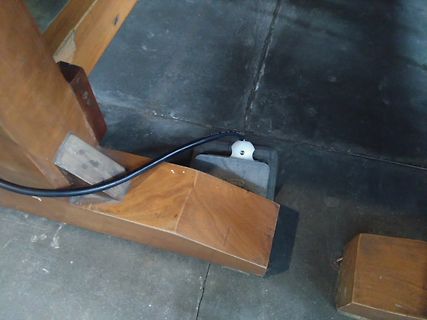 Schwarzes Kabel auf Holzkonstruktion und Betonboden