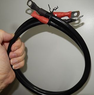 Hand hält aufgewickeltes Kabel mit Flachsteckhülsen