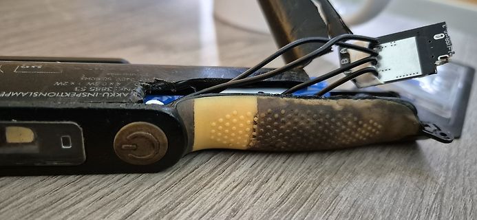 Beschädigte Taschenlampe mit verschmorten Kabeln und Gehäuse