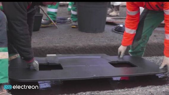 Arbeiter hantieren mit einer schwarzen Abdeckung
