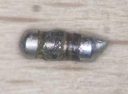 Metallisches Objekt auf Holzuntergrund