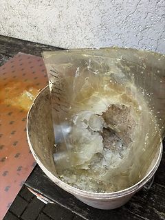 Eimer mit klebrigen Rückständen und Folie